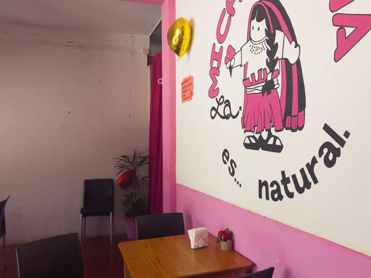 Salón interior con mural colorido de La Michoacana San Dionisio del Mar — ambiente festivo de la Guelaguetza 2026 del Istmo de Tehuantepec, Oaxaca